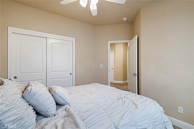 carpeted bedroom with a closet, baseboards, and ceiling fan