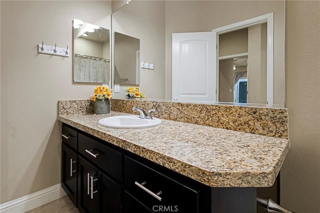 full bath with vanity and baseboards