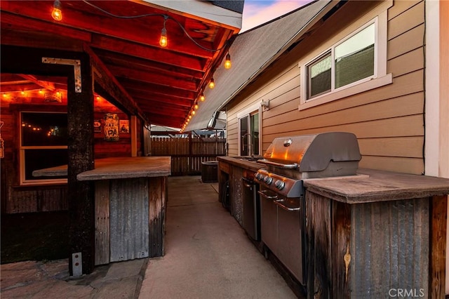 view of patio / terrace with an outdoor kitchen, fence, and area for grilling