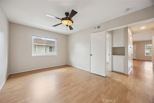 empty room featuring baseboards, light wood-type flooring, and ceiling fan