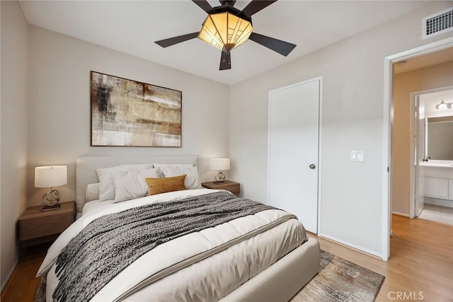 bedroom featuring baseboards, visible vents, a ceiling fan, and light wood-style flooring