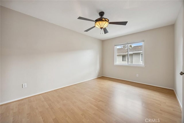 unfurnished room with ceiling fan, light wood-style flooring, and baseboards