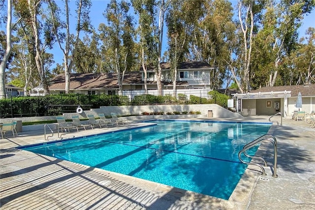 pool with a patio and fence