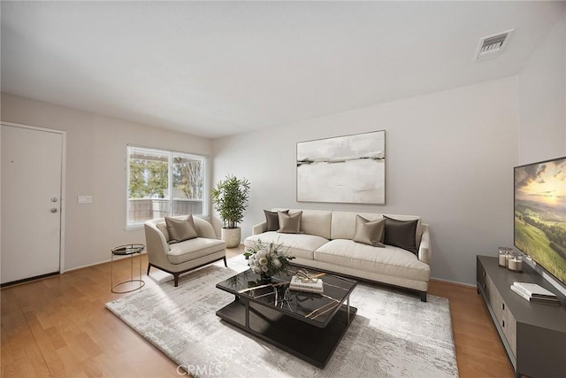 living area with wood finished floors and visible vents