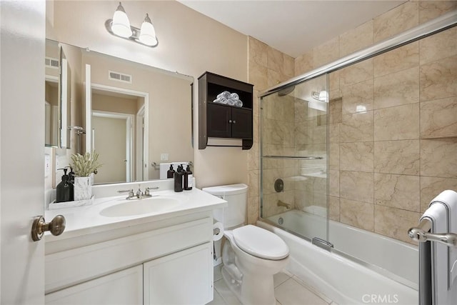bathroom featuring tile patterned flooring, shower / bath combination with glass door, toilet, vanity, and visible vents