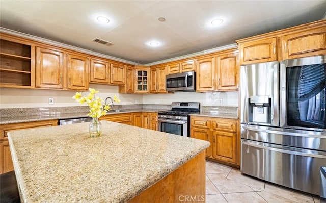 8707 Byers St, Downey, CA 90242 - kitchen with appliances with stainless steel finishes, a sink, light stone countertops, a center island, and light tile patterned flooring
