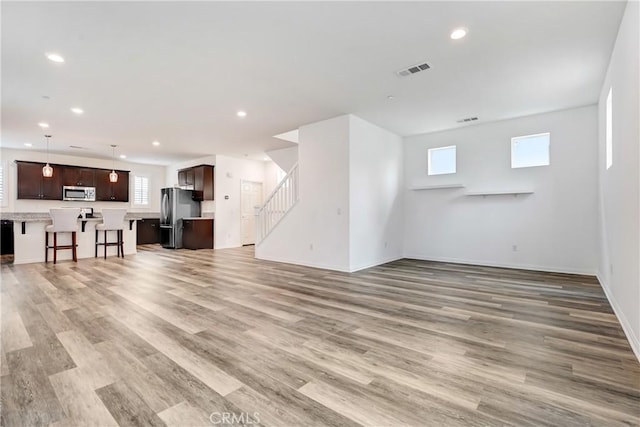 9126 Foster Ln, Chatsworth, CA 91311 - unfurnished living room with stairway, light wood-style floors, recessed lighting, and baseboards