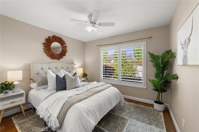 bedroom featuring wood finished floors, a ceiling fan, and baseboards