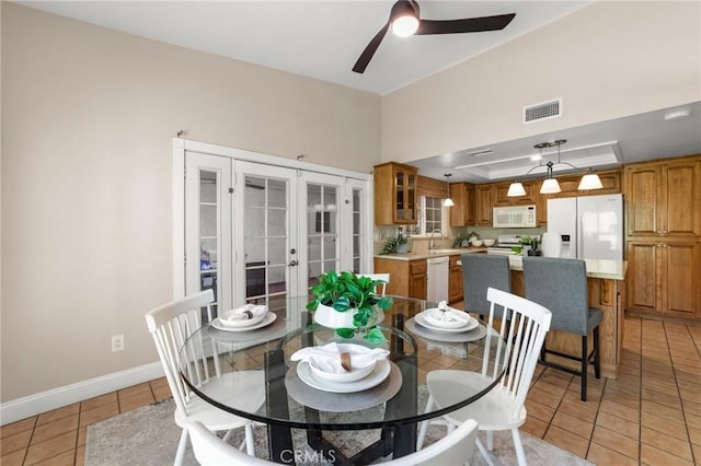 dining room featuring light tile patterned flooring, ceiling fan, visible vents, baseboards, and french doors