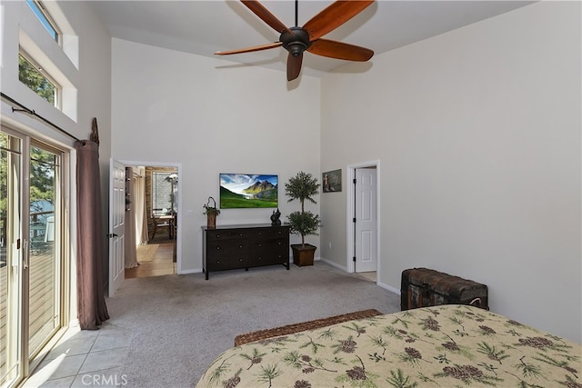 bedroom with light colored carpet, baseboards, access to outside, and a high ceiling