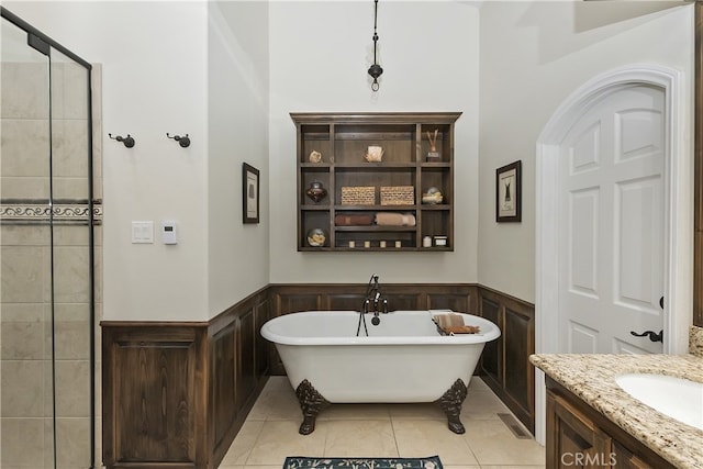 full bath with tiled shower, vanity, tile patterned floors, a wainscoted wall, and a freestanding bath