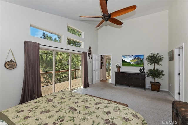 carpeted bedroom with a towering ceiling, a ceiling fan, and baseboards