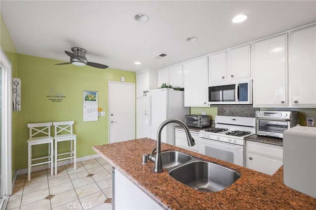 kitchen featuring a toaster, white appliances, ceiling fan, white cabinets, and a sink