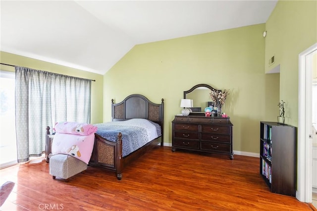 bedroom with visible vents, baseboards, wood finished floors, and vaulted ceiling