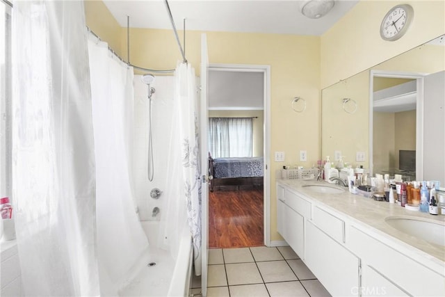 bathroom featuring connected bathroom, double vanity, tile patterned floors, and a sink