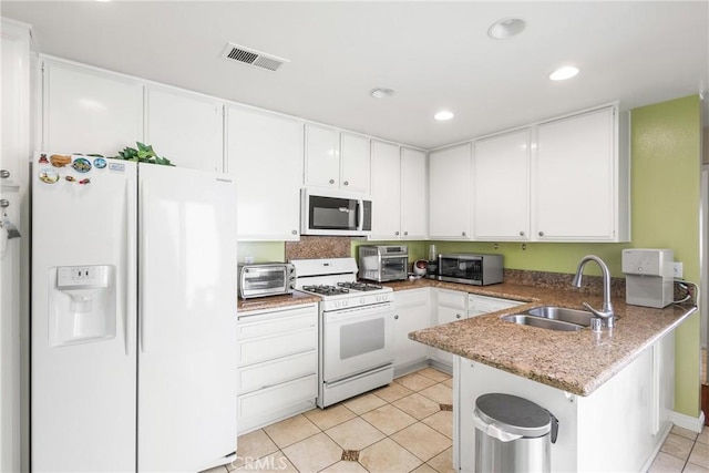 kitchen featuring white cabinets, a sink, white appliances, a peninsula, and visible vents
