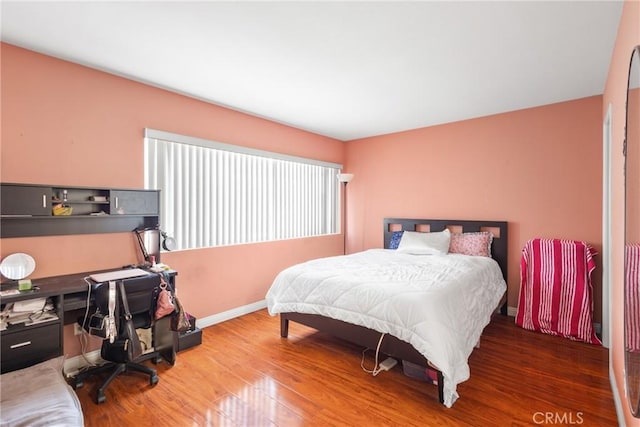 bedroom with baseboards and wood finished floors