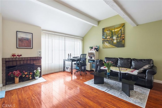 home office featuring vaulted ceiling with beams, baseboards, wood finished floors, and a fireplace
