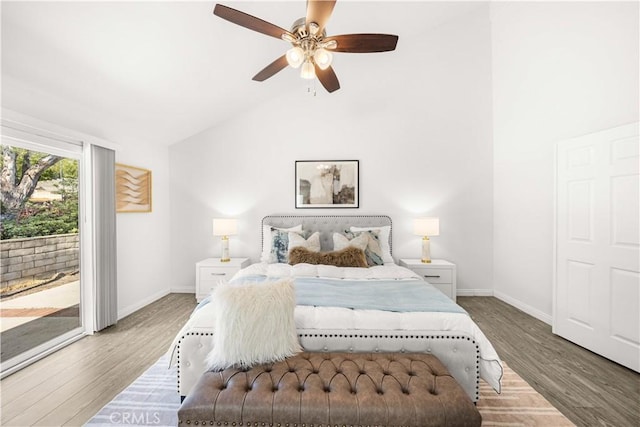 bedroom with baseboards, access to outside, high vaulted ceiling, and wood finished floors