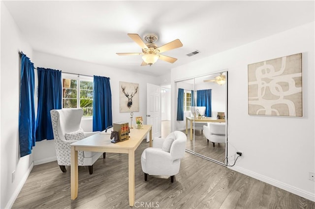 sitting room featuring ceiling fan, wood finished floors, and visible vents