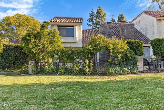 view of property exterior with stucco siding, a tile roof, and a lawn