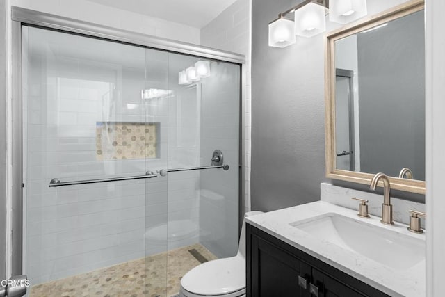 full bathroom with a stall shower, toilet, and vanity