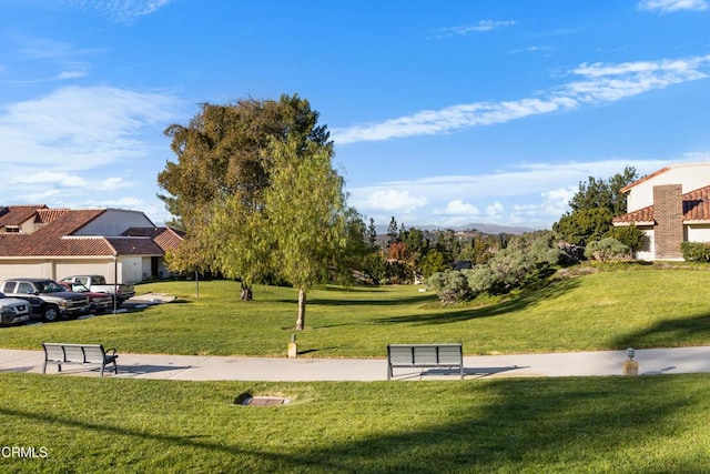 view of property's community with a mountain view and a lawn