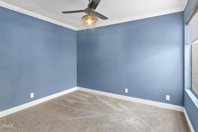 carpeted empty room with a ceiling fan, crown molding, and baseboards