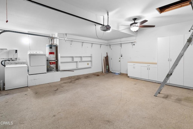 garage with a garage door opener, gas water heater, ceiling fan, and washer and clothes dryer