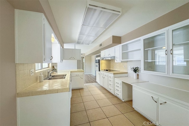 kitchen with a sink, light tile patterned floors, open shelves, backsplash, and white oven