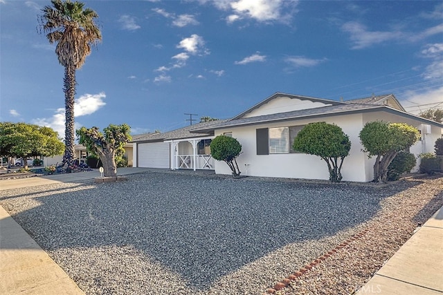 single story home featuring driveway, a garage, and stucco siding