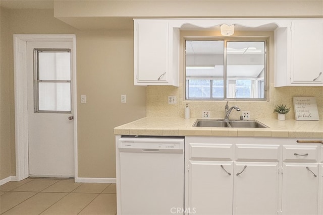kitchen with white cabinetry, a sink, baseboards, dishwasher, and backsplash