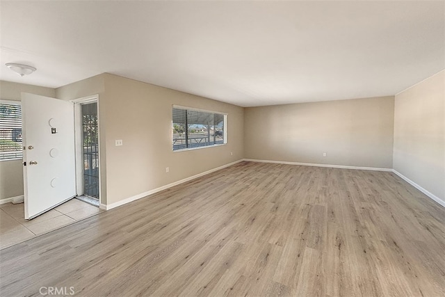 unfurnished living room featuring baseboards and light wood-type flooring