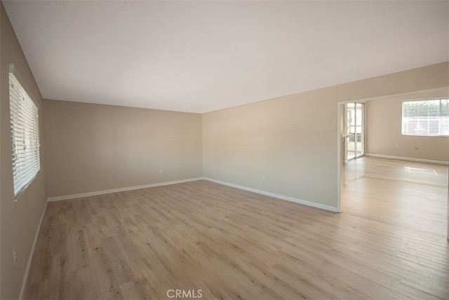 unfurnished room featuring baseboards and light wood-style flooring