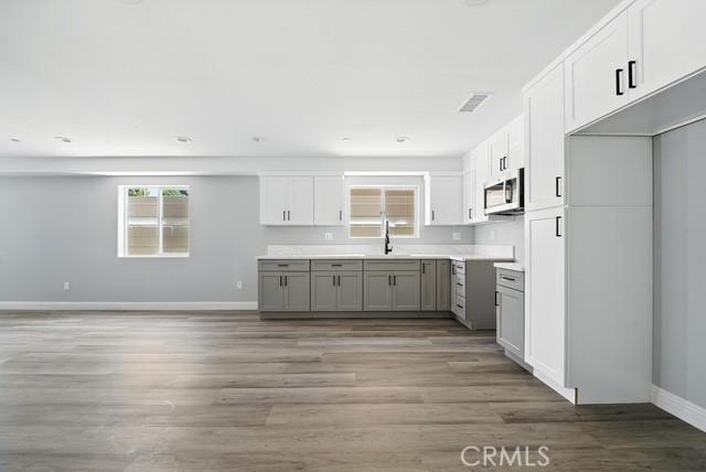 22020 Pioneer Blvd Unit A & B, Hawaiian Gardens, CA 90716 - kitchen featuring stainless steel microwave, gray cabinets, wood finished floors, and white cabinets