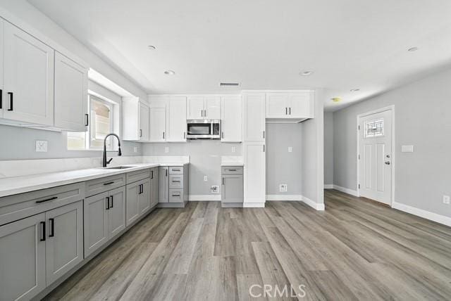 22020 Pioneer Blvd Unit A & B, Hawaiian Gardens, CA 90716 - kitchen featuring gray cabinets, stainless steel microwave, light wood-style flooring, plenty of natural light, and recessed lighting
