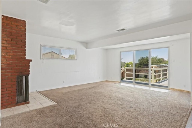 unfurnished living room with carpet floors, baseboards, visible vents, and a fireplace