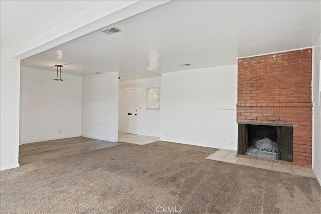unfurnished living room with carpet floors, visible vents, and a fireplace