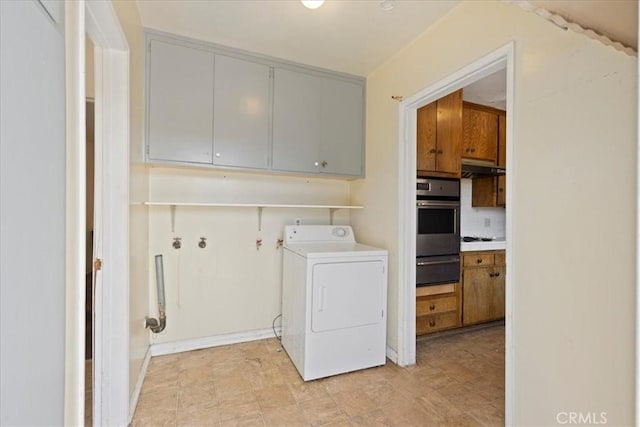 clothes washing area with washer / dryer and cabinet space