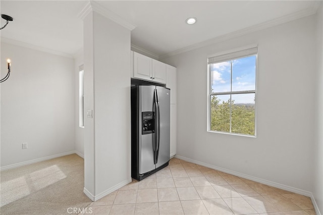 kitchen featuring stainless steel refrigerator with ice dispenser, baseboards, crown molding, and white cabinets