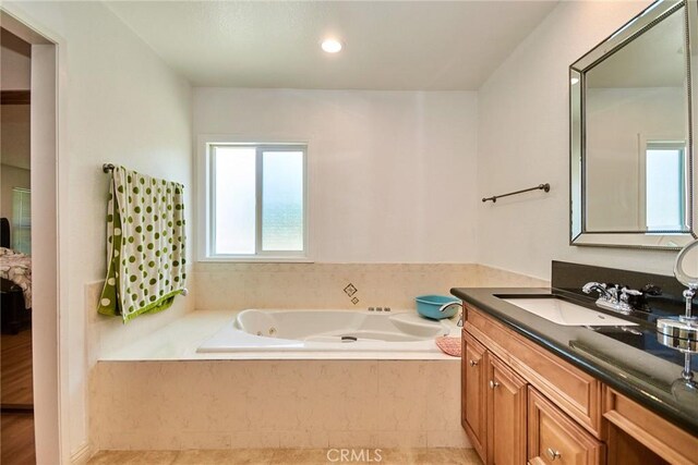 full bath with a tub with jets, tile patterned flooring, and vanity