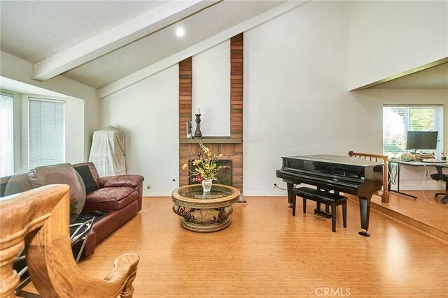 living area featuring a fireplace, wood finished floors, baseboards, vaulted ceiling with beams, and recessed lighting