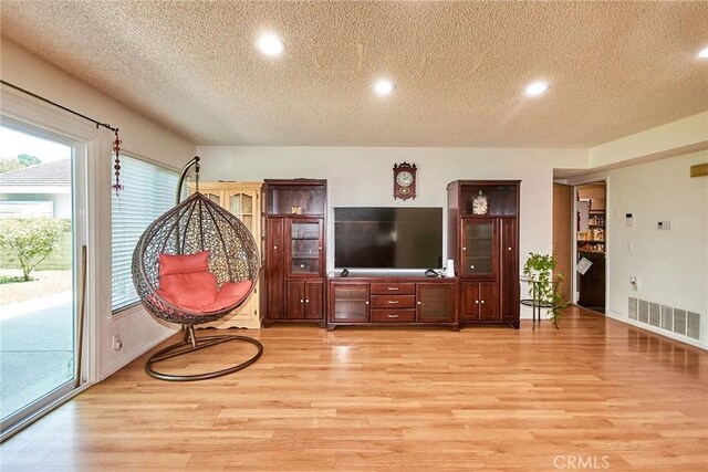 unfurnished living room featuring recessed lighting, a textured ceiling, visible vents, and light wood-style flooring