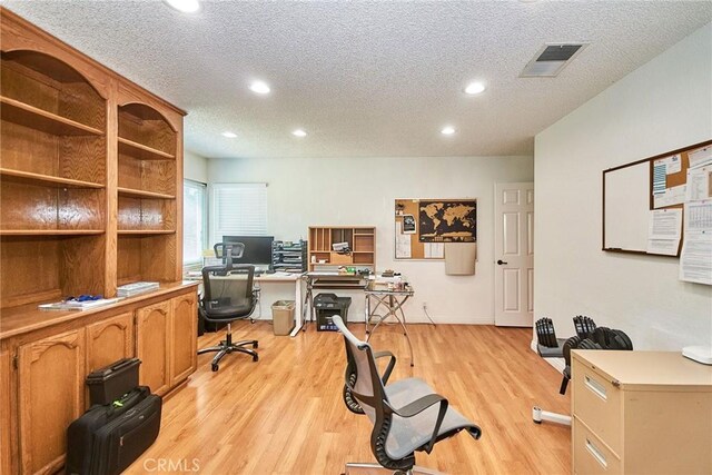 office space with visible vents, recessed lighting, a textured ceiling, and light wood finished floors