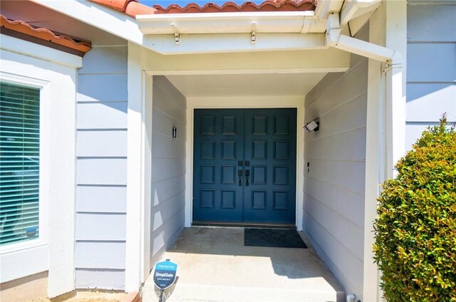 doorway to property featuring a garage and a tiled roof