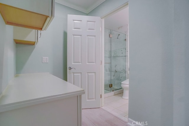 full bath featuring ornamental molding, a shower stall, and toilet