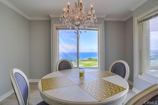 dining area with an inviting chandelier, crown molding, baseboards, and plenty of natural light