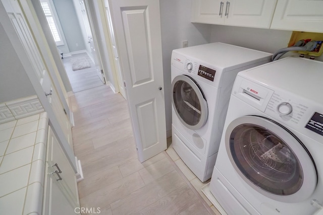 laundry area featuring separate washer and dryer and cabinet space