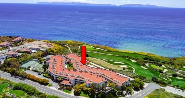 drone / aerial view with a water view and golf course view