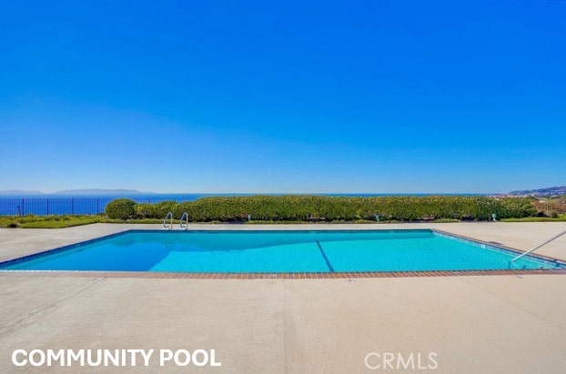 outdoor pool with fence and a patio area